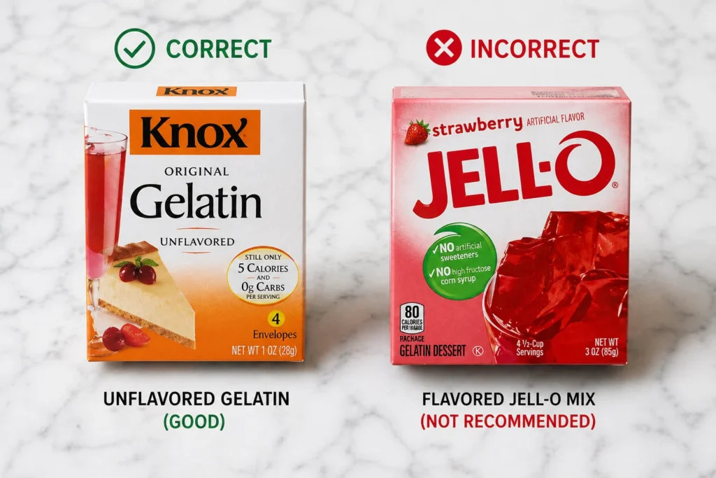 Pink hibiscus gelatin version of Kelly Clarkson jello recipe in a glass bowl, deep red color with hibiscus flowers on white marble surface.